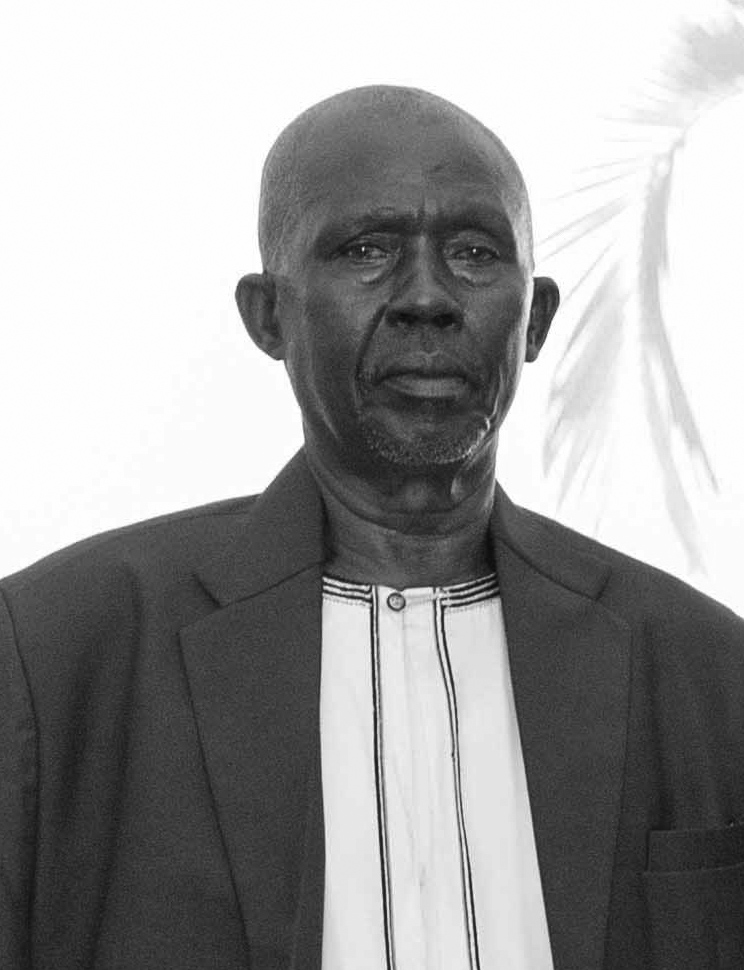 SharpMugabe's tweet photo. TRIBUTE: Remembering the Light and Wit of Aine Wilson Sharp

My father was, above all else, a passionate English teacher. I had the rare privilege of being his student; his gift for clarity made even the most complex concepts seem simple. In a moment like this, he likely would have found the perfect grammatical structure for the occasion: “No sooner had the internet been switched off than God called me to my permanent home.”

In 2017, a simple thorn prick on the finger changed my father’s life forever. We learned then how merciless diabetes can be; in less than four weeks, Dad lost his right arm. For a man who lived by the pen and the hoe, this could have been the end of his productivity. Instead, it was a new beginning. With incredible discipline, he taught himself to do everything with his left hand. He didn't just survive; he served. Whether as the church treasurer or the PDM village coordinator - filling out forms for those who couldn't write - he did more with one arm than most people do with two. This was the indomitable spirit of Aine Wilson Sharp.

Though he spent much of his career as a headteacher - a role that often commands fear - Dad was different. He earned a deep, instinctive respect from pupils and staff alike, not through intimidation, but through his character. He was the definition of humble, kind, and caring.

But the quality I will miss most was his incredible sense of humour. He had a rare alchemy - the ability to extract laughter from the gloomiest person in the room, no matter the circumstances. He lit up the darkness, and that light remains with us.

From drafting schemes of work to tending to the farms, Mzee was the embodiment of hard work and results. At his send-off, my brother, Katto, reminded us of our days in the garden. Just as we finished digging what we thought was a full day’s work, we would see Dad start another section (orugyezi) and begin again. This was typical of him; he taught us to never grow weary of honest labour.

He was also a man of firm principles. I remember well the day a neighbour’s chickens were stolen. When the thief’s tool, a knife from our own kitchen, was found at the scene, I was held answerable since the kitchen was my department! It was a difficult day of reckoning until an eyewitness surfaced and the true culprit was caught. The thief had slipped into our home while we slept, but Dad’s lesson stayed with me: accountability matters, and negligence has consequences.

See you when we meet again. May Your Soul Rest in Eternal Peace, Dad.