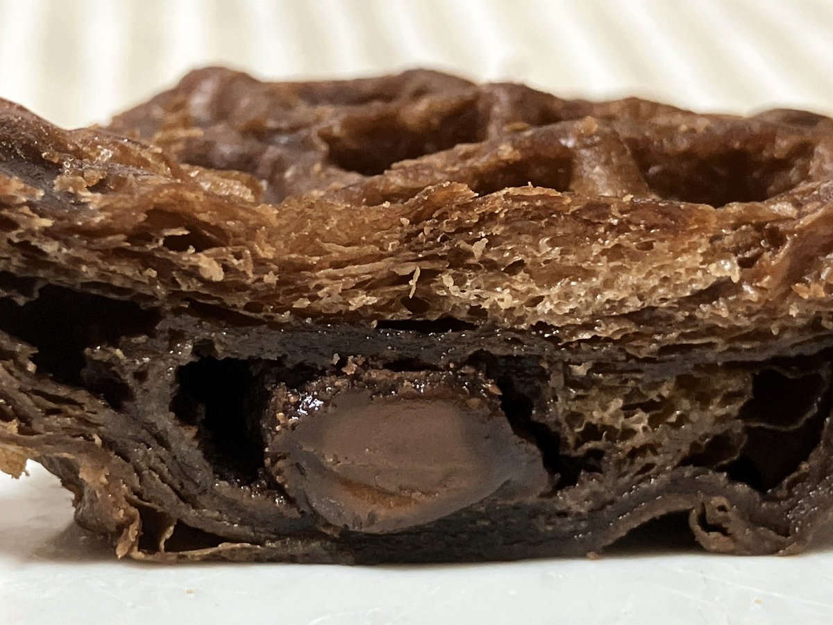 ファミリーマート クロワッサンワッフル チョコ入り。生地は歯切れ良くしっとり、マーガリンの風味と甘さがありチョコデニッシュのよう。中のチョコはコリっと程良い硬さ、ほんのりビター感があり甘すぎない。温めるとチョコの風味が際立ってチョコづくしを堪能できおいしかった。