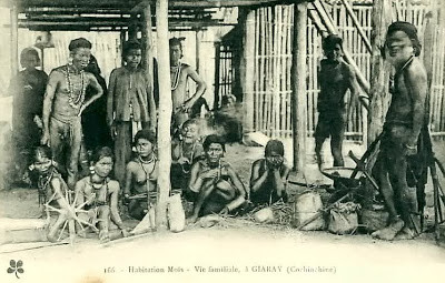 TheMatriarchX's tweet photo. **Nadal #96. Giaray, circa 1928. “Habitation Mois – Vie familiale.” Real frame. Fictional breath.**

The house breathes.

Fifteen bodies under one roof of elephant grass.

**Y Ksor** stands left, hand on the pillar he felled with a stone axe—his grandfather’s axe, still sharp enough to split French skulls if needed. His loincloth is smoked fish and sweat. **H’Rai** beside him twists cotton on a spindle that hums like a trapped bee; each thread a promise to clothe the child at her feet.

Center, **H’Blang** squats over the fire, blowing life into embers with a bamboo tube. Smoke curls around her breasts like it’s done for a thousand nights—no curtain, no shame. The pot is clay older than the caption.

Children weave between legs: one chews sugar cane, another fingers a porcupine quill. A baby nurses openly; milk drips, nobody wipes it.

Back row, **Y Thip** leans on a crossbow taller than the Frenchman who’ll never see it. His eyes are on the forest, not the lens.

The photographer—sweating in wool—arranges them like furniture. He titles it *“vie familiale.”* He crops the crossbow, blurs the spindle, zooms on bare skin. Wants poverty porn, not pulse.

But smell the air: ginger, fish, earth. Hear the spindle sing. Feel the heat of bodies that belong here.

This isn’t a habitat.
It’s a heartbeat.

The camera came to document extinction.
They gave it life.