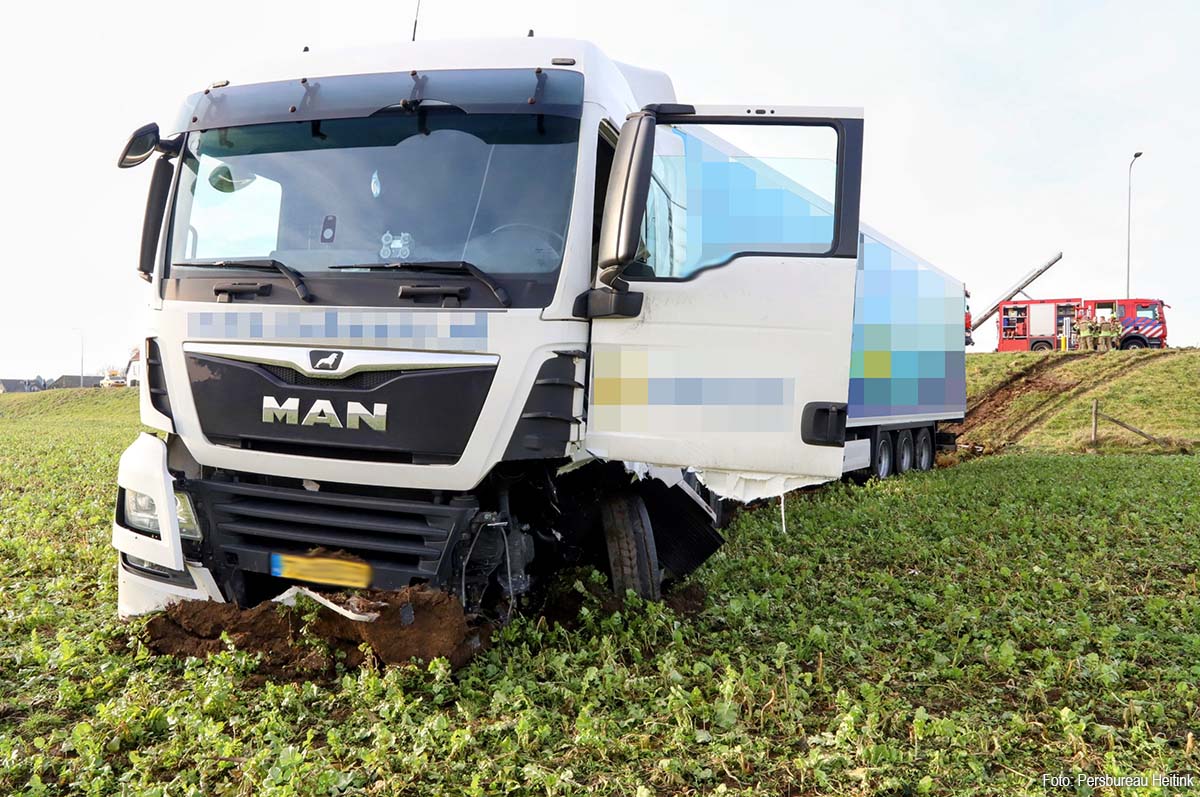Vrachtwagen van dijk na botsing met personenauto