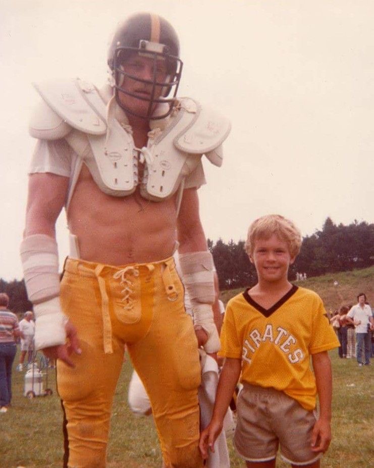 An NFL football player standing next to a kid (Sometime in the 1970s)