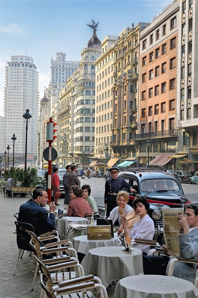 Una instantánea de la Gran Vía, en Madrid, en torno a 1959. Gente tomando tranquilamente un piscolabis en una terraza. A la altura del Teatro Lope de Vega. Cuando se podía estacionar en esa avenida.