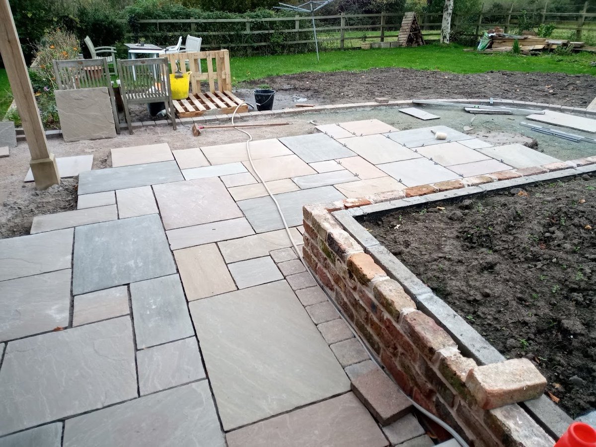 Intellland's tweet photo. Patio in progress with particular care to ensure consistent grout lines and not to wide (always looks better) the devil is in the detail... cobble edging adds a nice detail https://t.co/01acoMuzxx