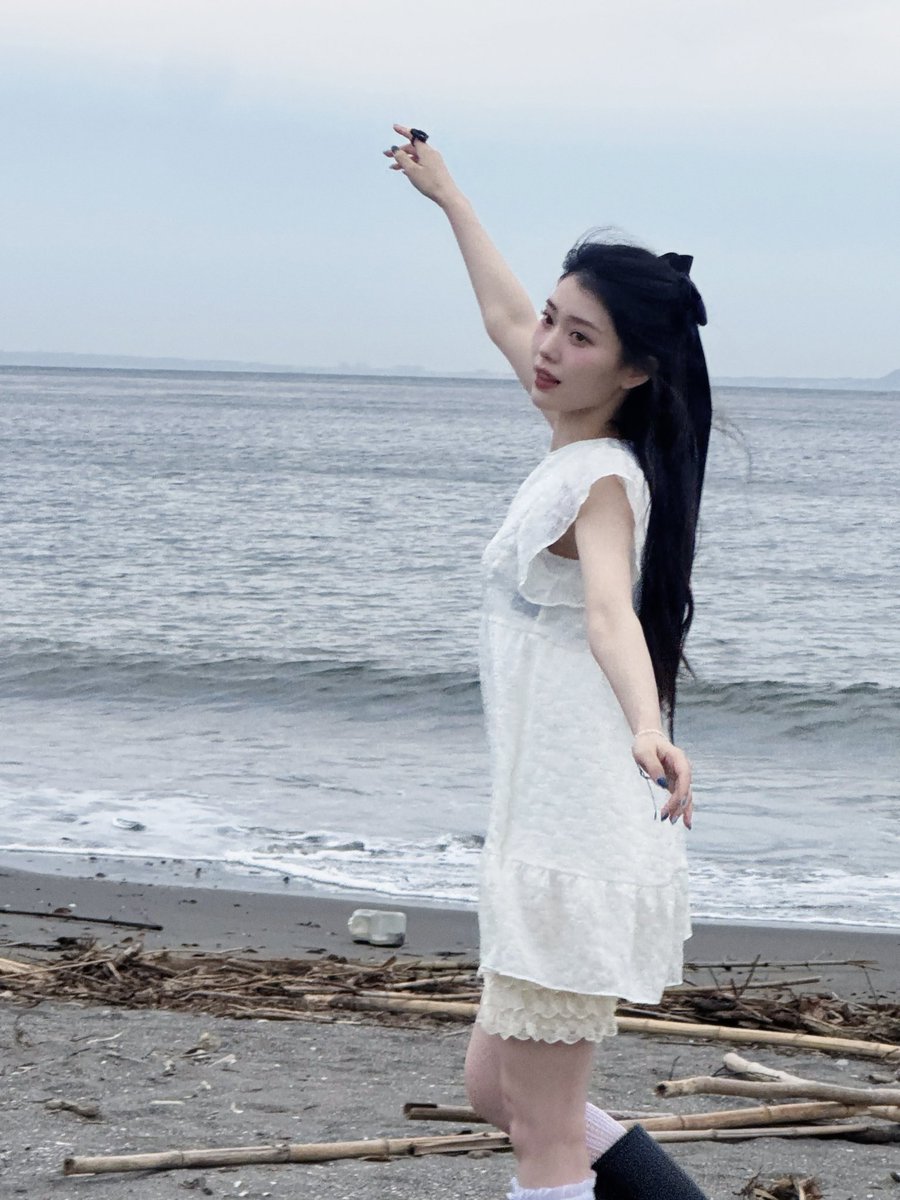 xiaotuing's tweet image. I stand a little taller, letting the sea air pass softly.  

𖦹°·𓇼 This higher angle keeps my expression clear and steady. Behind me, the shoreline stretches wide, with distant shapes resting far away, giving space to breathe, smile softly, and enjoy a slow summer pause.  ⋆˚࿔