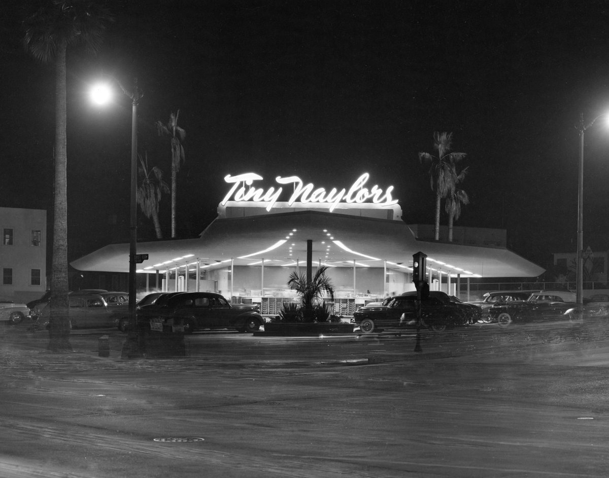 Atmospheric night shot of Tiny Naylor’s first drive-in restaurant on the northwest corner of Sunset Blvd and La Brea Ave, Hollywood, 1949. There were around 8 Tiny Naylor drive-ins. Can’t you almost smell the burgers, coffee, cigarettes, and fries in this one?