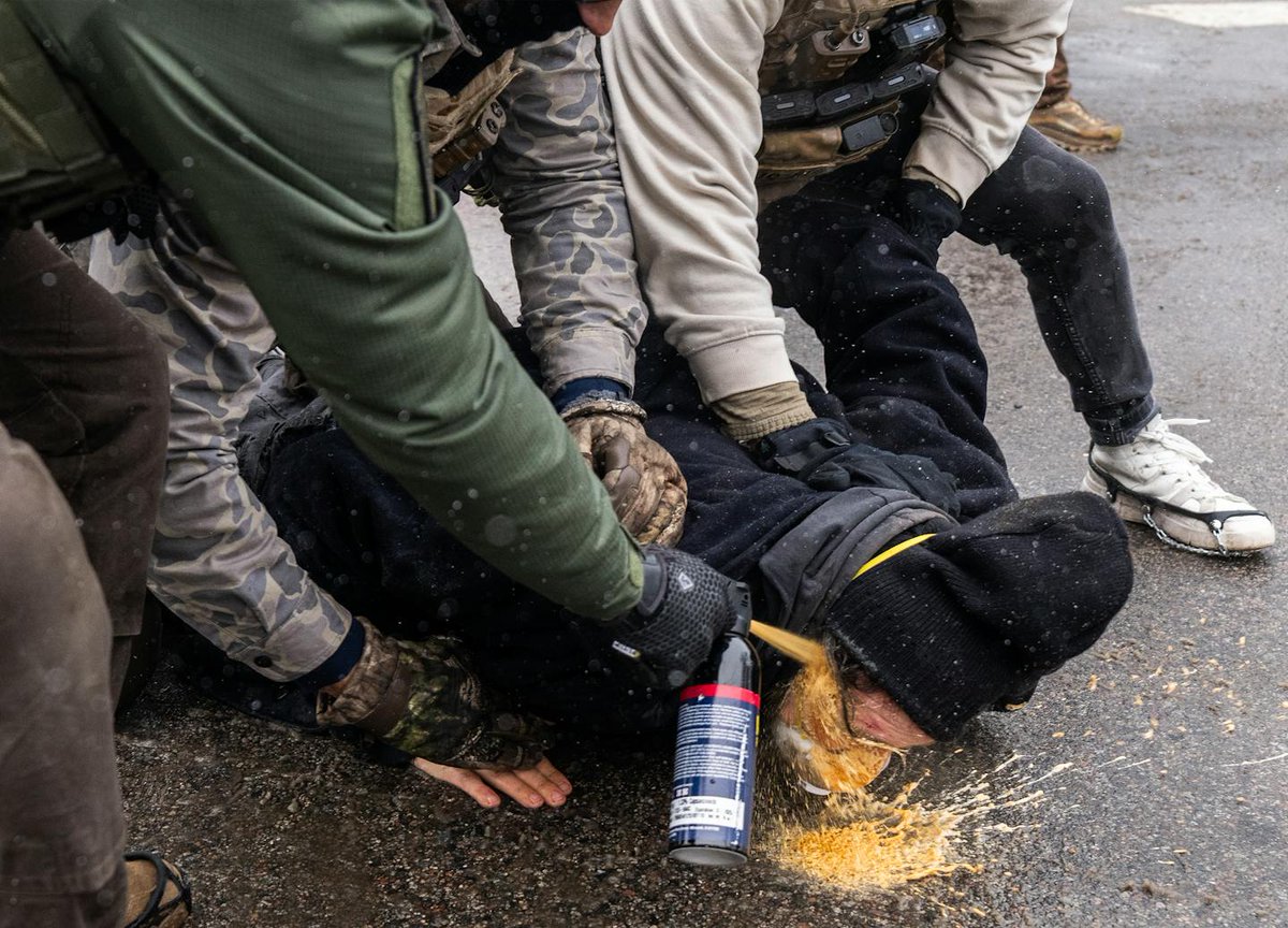 factpostnews's tweet image. New photos reveal federal agents holding a protester to the ground as they spray chemical irritant directly into his face.