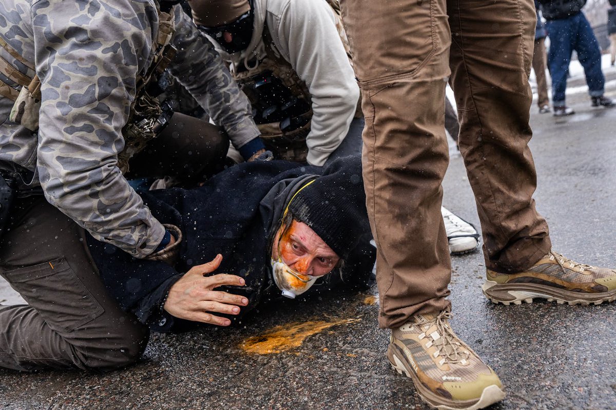 New photos reveal federal agents holding a protester to the ground as they spray chemical irritant directly into his face.