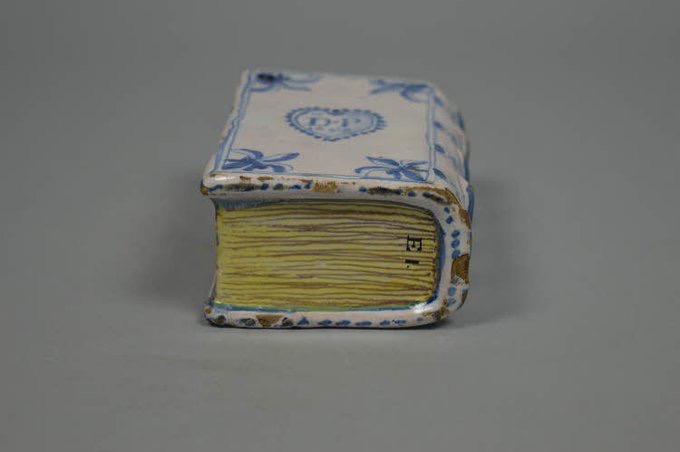 jdmccafferty's tweet image. Ornament (perhaps a hand-warmer or flower holder), tin-glazed earthenware, moulded in the form of a book, 1658 from #Southwark (BM)