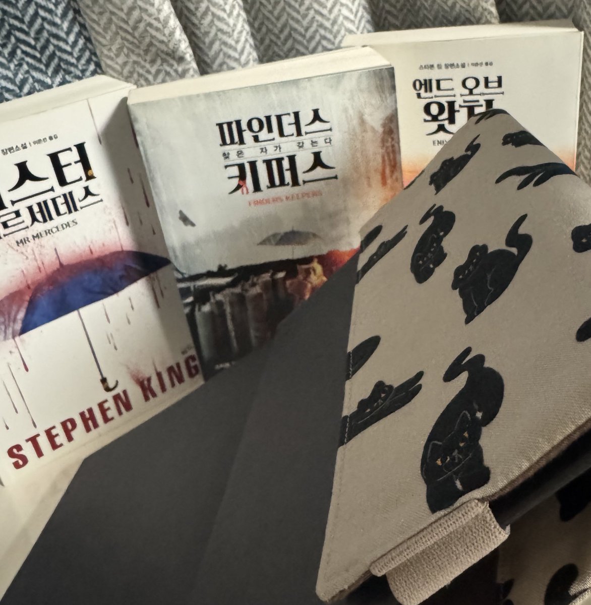 lee_p_bbb's tweet photo. @gingerywpd 생강님 안녕하세요 제가 많이 늦었죠🥹 호지스 3부작을 배경으로 사진을 찍어보았어요! 북커버는 기존 스티븐킹 양장본에 완벽하게 딱 맞는 사이즈입니다👍🏻 앞날개 뒷날개를 감쌀 수 있을 뿐 아니라 밴드로 고정할 수 있는 점이 정말 좋았어요🥰 주말에 실사용하고 또 후기 남길게요! 정말 감사합니다! https://t.co/vg59p0Ruo8