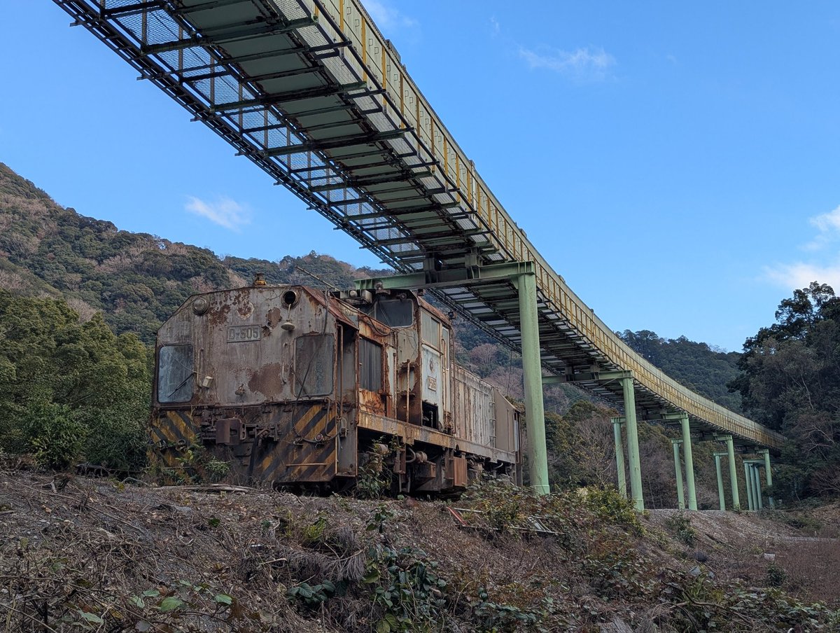 専用線の廃線跡に残る機関車。その上に伸びるのは、鉄道から置き換え