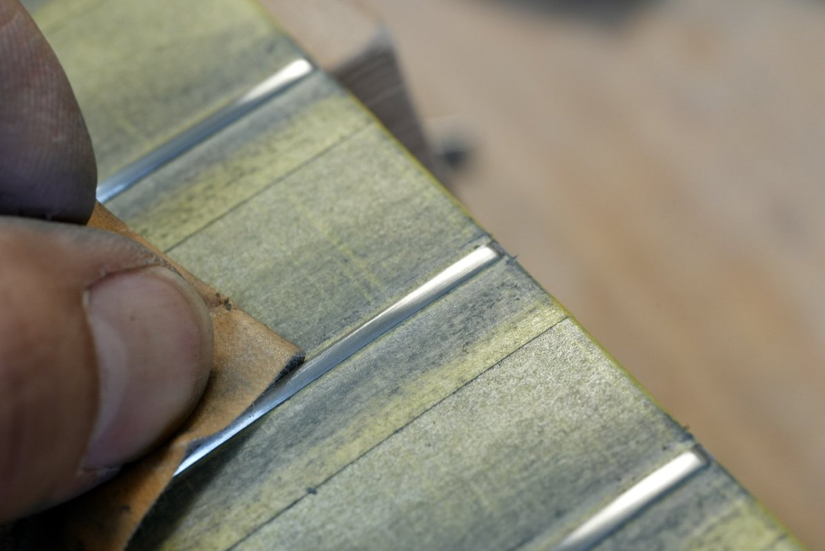 LeafInstruments's tweet image. 【じんさんのギターメンテ記録】
フレットがいくらかすり減っていたので、「すり合わせ」を行います。

フレットの頂点を均等に削り、高さを揃えます。
台形になった形を金ヤスリで半円に近づけます。
3枚目の写真、2弦がくるであろう場所がまだ少し凹んでいますね。…