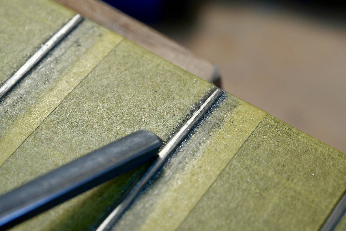 LeafInstruments's tweet image. 【じんさんのギターメンテ記録】
フレットがいくらかすり減っていたので、「すり合わせ」を行います。

フレットの頂点を均等に削り、高さを揃えます。
台形になった形を金ヤスリで半円に近づけます。
3枚目の写真、2弦がくるであろう場所がまだ少し凹んでいますね。…