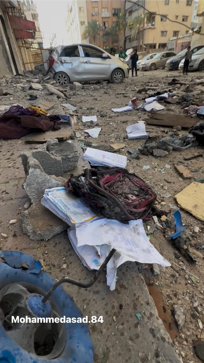 🚨HORRIFIC: Toys, a backpack, and schoolbooks scattered in the street, children killed in their sleep at dawn today after an Israeli airstrike struck their home in Gaza.