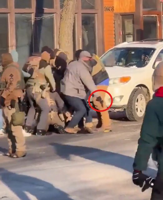 Alpha7021's tweet photo. WATCH: Two different angles seemingly show a federal officer disarming the 37-year-old Alex Jeffrey Pretti ,before he was shot and killed in the shooting in Minneapolis.

The agent in the grey jacket and baseball cap can be seen removing the firearm and then walking away as his colleagues shoot the man.