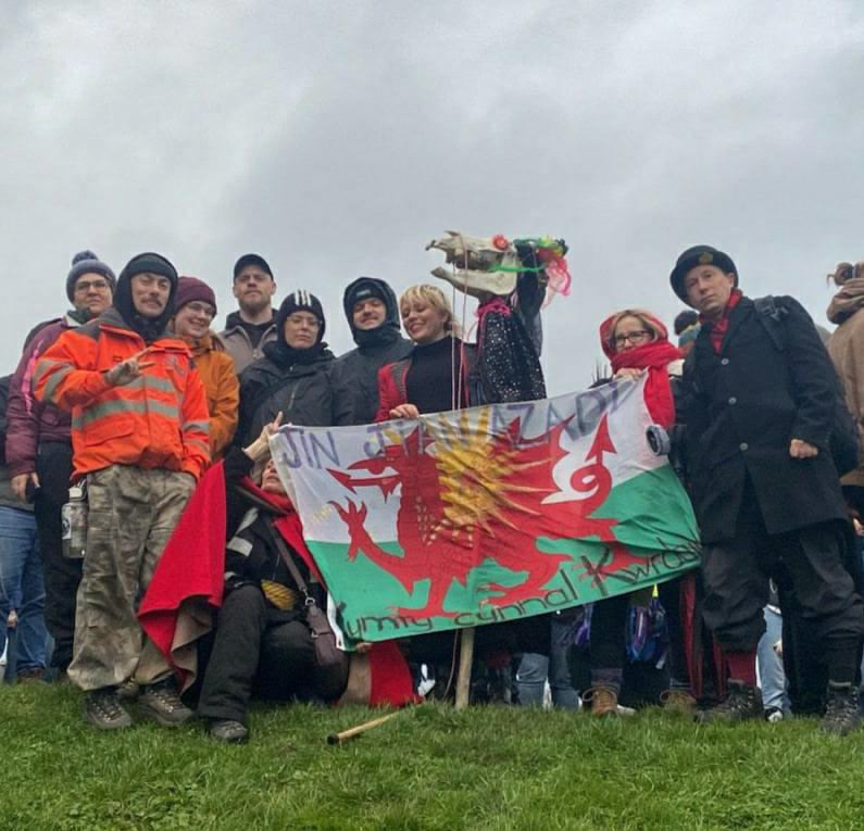 RISEUP4R0JAVA's tweet photo. In Cas-Gwent, Wales, today a gathering of the Fari Lwyd - an old welsh tradition on the hen galan stand together in solidarity with the People of Rojava.

(Image shows crowd with Fari Lwyd holding the Welsh and Kurdish solidarity Banner with the words Jin Jiyan Azadi on it) https://t.co/GNmkWT2Keg
