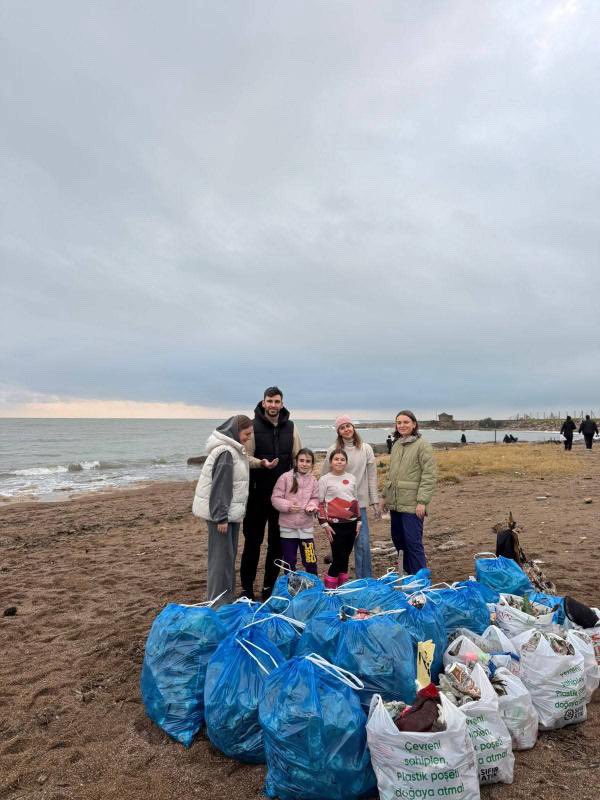 Antalya’da Rus bir aile Örnekköy plajındaki çöpleri topladı