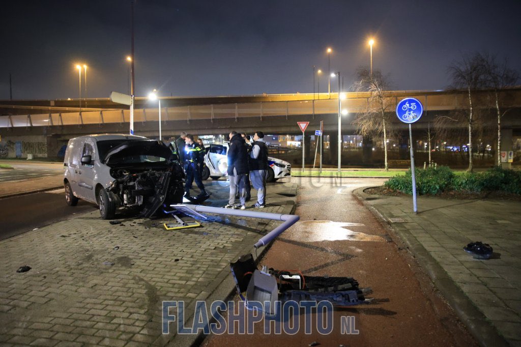 Forse schade na botsing busje tegen lantaarnpaal in Rotterdam