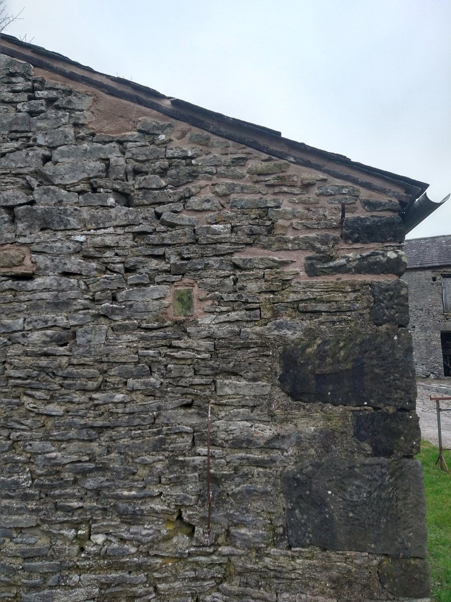 Barn roof repaired, re-slated and the wall rebuilt with limestone mortar.