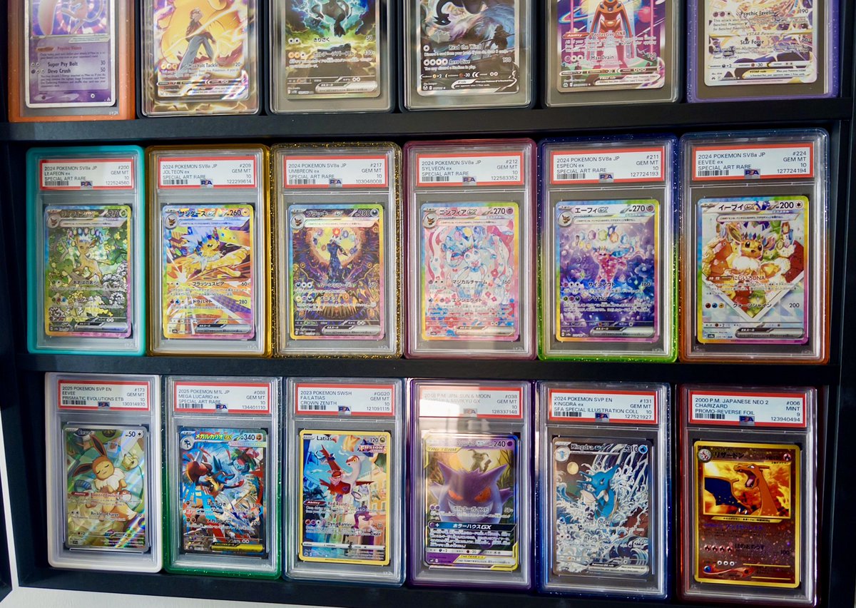 my display case so far, i think im going to rotate something out this week. i got like 100 other slabs just chilling in a box and i want to have some time with them. i don’t think i can put away my illustration promo baddies but i might swap out the eeveelutions