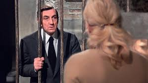 merlinpapin3's tweet photo. #DéfiCinéClassique2026 (Ingrid Thulin) Vu le Film #LaCage de Pierre Granier Deferre (1975) avec Lino Ventura Ingrid Thulin Dominique Zardi William Sabatier Jean Turlier Sophie Sam

Julien, la cinquantaine, est promoteur immobilier. Il se rend, un soir, dans une villa isolée de banlieue. Son ex-femme, Hélène, qu'il n'a pas vue depuis deux ans, l'y attend, seule. Son intention: vendre cette maison qu'il lui avait offerte en guise de cadeau de séparation.

La Cage est un thriller des années 70, quasi huis clos, adapté d’une pièce de Jack Jacquine, qui repose sur une idée forte mais mal exploitée : la séquestration par amour. Sur le papier, le concept intrigue. À l’écran, il interroge… sans jamais vraiment répondre.

Pierre Granier-Deferre, cinéaste habituellement solide (Le Chat, La Veuve Couderc), enferme ici son film — et son spectateur — dans une cave, au sens propre comme au figuré. Le dispositif est simple : Julien, interprété par Lino Ventura, se retrouve piégé par son ex-femme Hélène, incarnée par Ingrid Thulin, qui l’enferme dans la cave de sa propre maison. Le piège se referme très vite, presque trop vite, comme si le film craignait déjà sa propre stagnation.

Voir Lino Ventura en position de faiblesse est rare, presque dérangeant. Lui, le roc, le taiseux, le taulier du polar français, devient ici une proie passive. Et le problème est là : Julien n’est pas McGyver, certes, mais il ne tente pas grand-chose non plus. Peu d’élan, peu d’ingéniosité, peu de rage. On attend un sursaut, une étincelle… qui ne vient jamais.

Face à lui, Ingrid Thulin impose une présence froide, distante, presque clinique. Elle joue Hélène comme une énigme permanente. Trop permanente. On ne sait jamais vraiment ce qu’elle veut : se venger ? aimer encore ? punir ? retenir ? Et le film ne tranche pas. Ce flou, au lieu de nourrir le malaise, finit par l’épuiser.

La mise en scène de Granier-Deferre est fonctionnelle, sans audace particulière. Le huis clos pourrait étouffer, oppresser, faire monter une tension psychologique digne d’un Polanski. Mais ici, la cave devient vite monotone, et la caméra semble aussi prisonnière que son personnage principal.

Le scénario, pourtant prometteur, tourne en rond. Les reproches d’Hélène à Julien sont bien le cœur du film, son moteur dramatique, mais ils restent abstraits, jamais pleinement incarnés. Séquestrer quelqu’un par amour est une idée forte, presque fascinante — mais comme je ne suis pas psy, je laisserai la science y répondre… le film, lui, n’y répond pas.

Le rythme démarre bien, puis s’enlise. Et cela dure jusqu’à une fin bâclée, expédiée, frustrante. On regarde jusqu’au bout en espérant un dénouement qui nous collerait une gifle. Mais non. Le générique arrive. Rideau. Circulez.

La Cage n’est clairement ni le meilleur Granier-Deferre, ni un grand Lino Ventura. Mais on lui pardonne. Par respect. Par affection. Par fidélité à une époque où même les faux pas avaient une certaine tenue.

Un film qui enferme plus qu’il ne libère. Et qui laisse son spectateur dans la cave, lumière éteinte.

La Cave se rebiffe

@FredOL69007

❤️si vous aimez