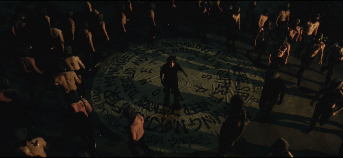 The circle Chanhee's standing in has the last stanza of Goethe's poem 'Prometheus' (translated to English): 

Here sit I, forming mortals
After my image;
A race resembling me,
To suffer, to weep,
To enjoy, to be glad,
And thee to scorn,
As I.