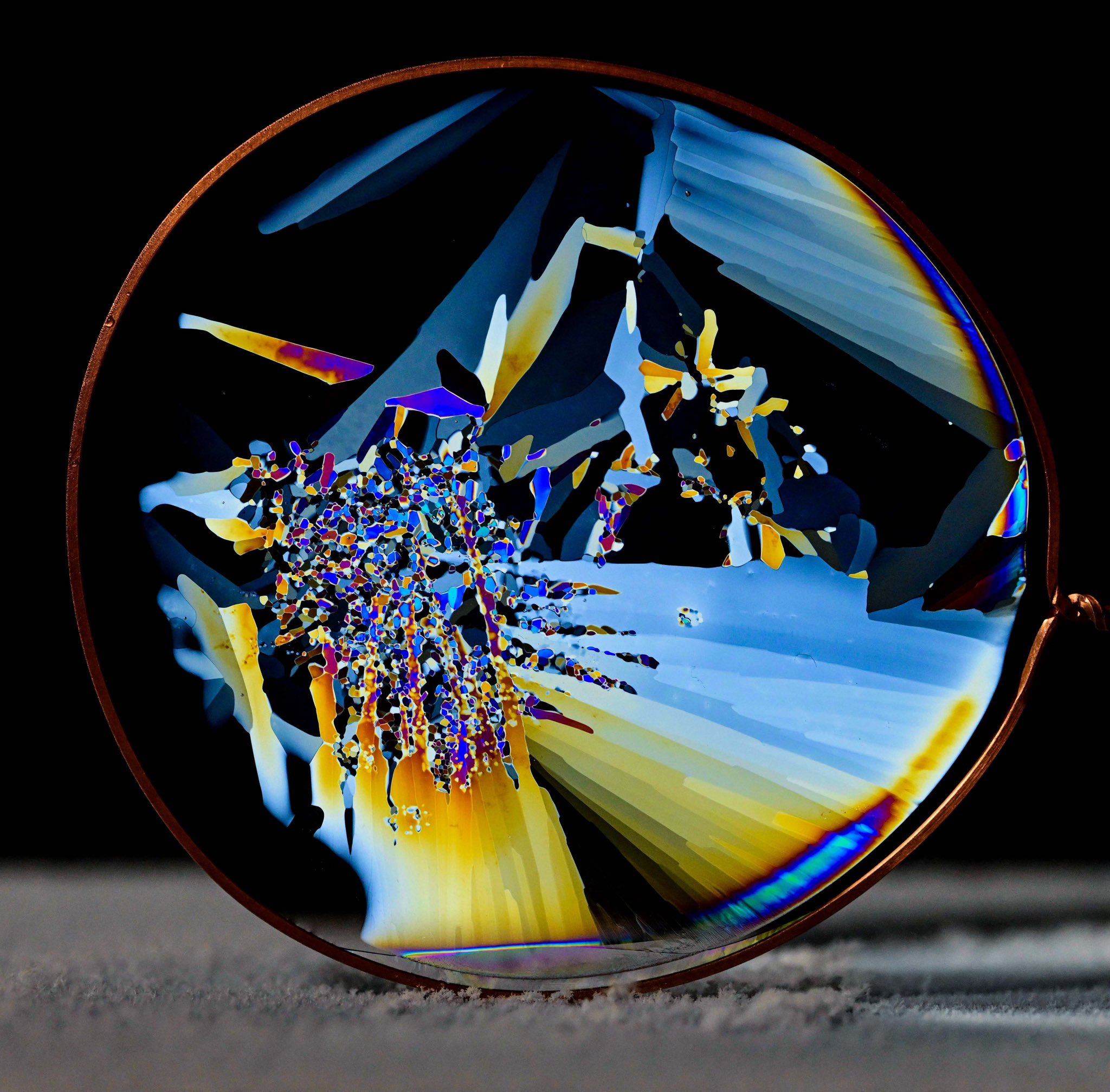 Colorful, fragmented ice crystals are seen in a circular shape.