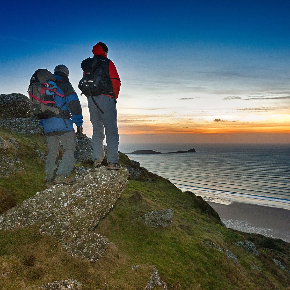 WalesCoastUK's tweet photo. Walkers enjoying a sunset over Rhossili Bay, with Worm's Head in the background.
What a way to end a day of walking on the coast path!

#WalesCoastPath #LlwybrArfordirCymru #Wales #Cymru #CroesoCymru #WormsHead #Rhossili #RhossiliBay #Sunset #DiscoverWales #MyWales #CaruCymru https://t.co/SEeQzmyWZ9