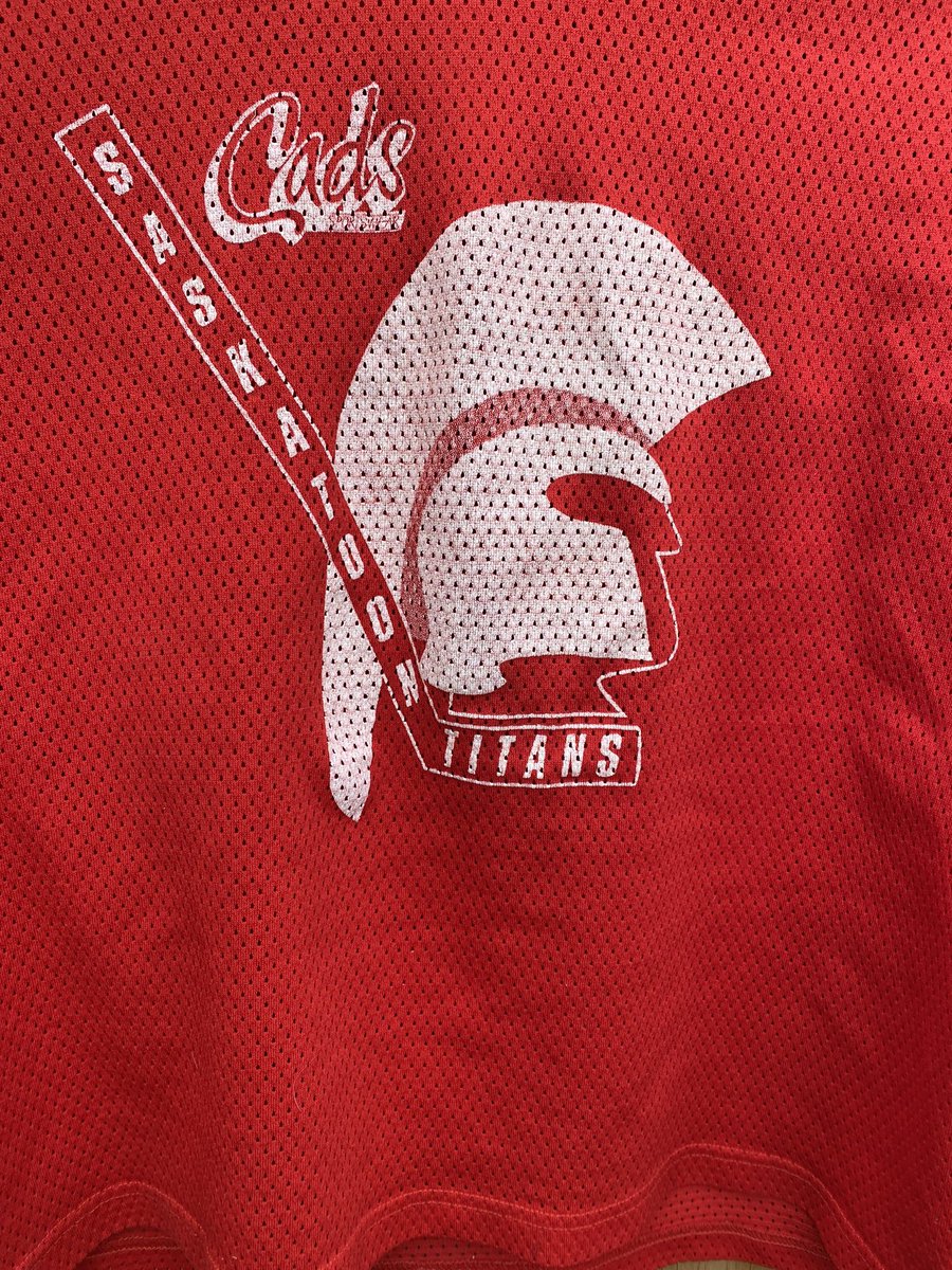 JamieWoodrow2's tweet photo. Going through a bag of practice Jerseys and found this old relic. Anyone else remember the Saskatoon Titans of the SJHL. Buddy gave me this after he came home from the camp. @BGIKG @MondayNooner @theSJHL @RodPedersenShow #saskjuniorhockey, #thingsyoufind #oldjersey https://t.co/Bw9wPkbkkg