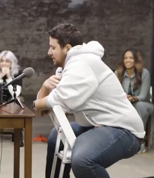 No man sits like this when meeting another man for the first time. This is a woman’s idea of how men sit together based on imitating the mannerisms of A.C. Slater from Saved By the Bell.