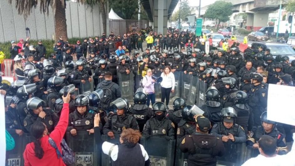MiguelMezaC's tweet photo. El encapsulamiento contra dos juezas es abuso de funciones y viola la Ley Nacional sobre el Uso de la Fuerza.

Hay al menos 70 granaderos inmovilizándolas.

La inmovilización solo se justifica ante agresiones. Ellas no agreden a nadie,solo defienden sus derechos con un megáfono:

La Ley Nacional sobre Uso de la Fuerza establece varios principios que todas las fuerzas de seguridad deben seguir al utilizar la fuerza contra civiles.

Hay dos principios muy importantes para este caso: absoluta necesidad y proporcionalidad.

El principio de absoluta necesidad establece que el uso de la fuerza es la última alternativa que las autoridades pueden utilizar contra un agresor (artículo 4, fracción I) que pone en riesgo a personas, el orden o la paz pública.

Dos juezas que defienden la independencia del Poder Judicial con un megáfono no son unas agresoras, aunque este gobierno las haya convertido en sus enemigas públicas.

Por otro lado, el uso de la fuerza debe ser proporcional al nivel de resistencia y riesgo del agresor (artículo 4, fracción IV).

Utilizar a más de 70 granaderos para encapsular a dos juezas cuyo nivel de riesgo es cero, es absolutamente desproporcionado.

No solo es violatorio de la Ley Nacional sobre el Uso de la Fuerza. También vulnera los derechos a la libertad de expresión, libertad de movimiento y muchos otros.

Las personas responsables de estos operativos deberían ser sancionadas. La fuerza pública es para garantizar la seguridad de la población, no para amedrentar a quienes defienden la democracia.