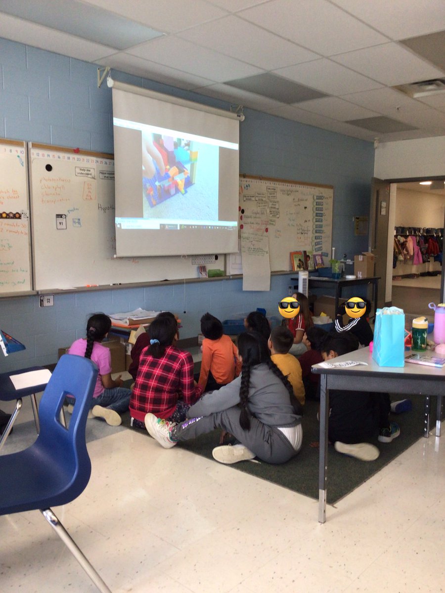 Students watching a video created by a classmate who created a complete airport using Lego and his imagination