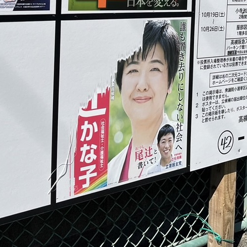 衆議院選挙の公営掲示板に尾辻かな子のポスターが貼られている写真。ポスターの左上、名前の部分が破られている。