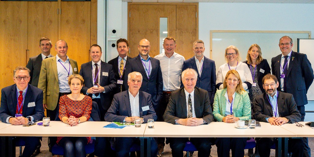 Members of the Food and Drinks Sector Committee stood and sat around a boardroom table, with Minister Zeichner sat in the middle of the group.