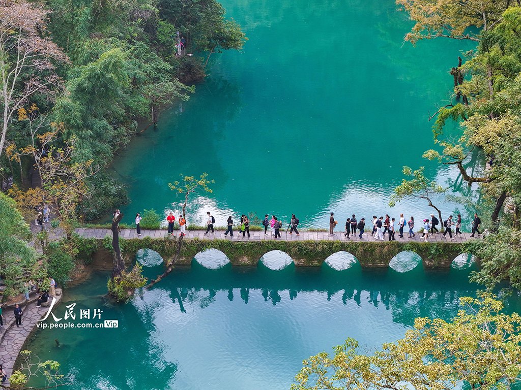 PDChinaLife's tweet photo. The Xiaoqikong scenic spot featuring an ancient stone bridge with seven arches allures visitors to impressive vistas including rushing waterfalls and crystal clear waters in Libo County, southwest China's Guizhou Province. #TravelInChina https://t.co/4dbZlSzk7I