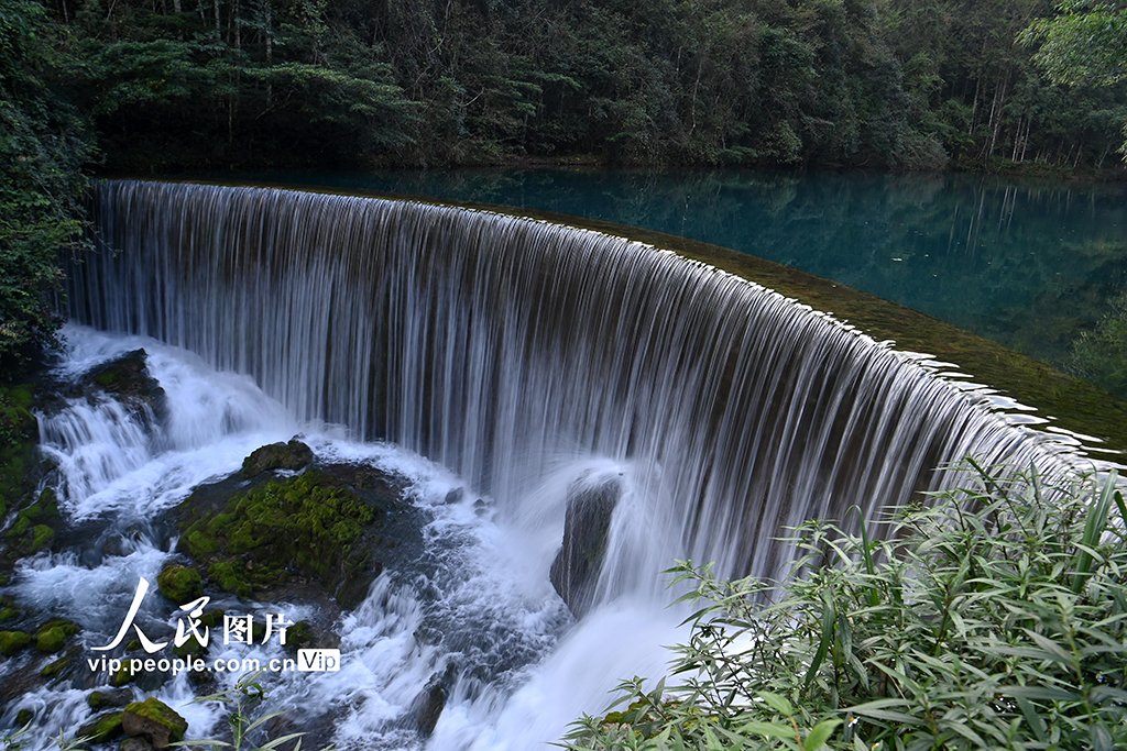 PDChinaLife's tweet photo. The Xiaoqikong scenic spot featuring an ancient stone bridge with seven arches allures visitors to impressive vistas including rushing waterfalls and crystal clear waters in Libo County, southwest China's Guizhou Province. #TravelInChina https://t.co/4dbZlSzk7I
