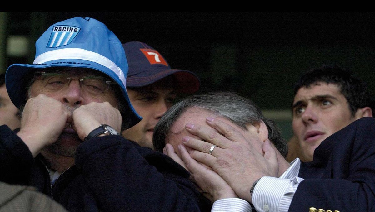 Clausura 2003: Racing 0 - Olimpo 2, Kirchner y Gines reaccionan al segundo gol de Cristian Castillo, ante la atenta mirada de un joven Osvaldo "Pucho" Barsotini, al otro día, Néstor asumió la presidencia de Argentina. 

De las mejores fotos de un presidente en una cancha.