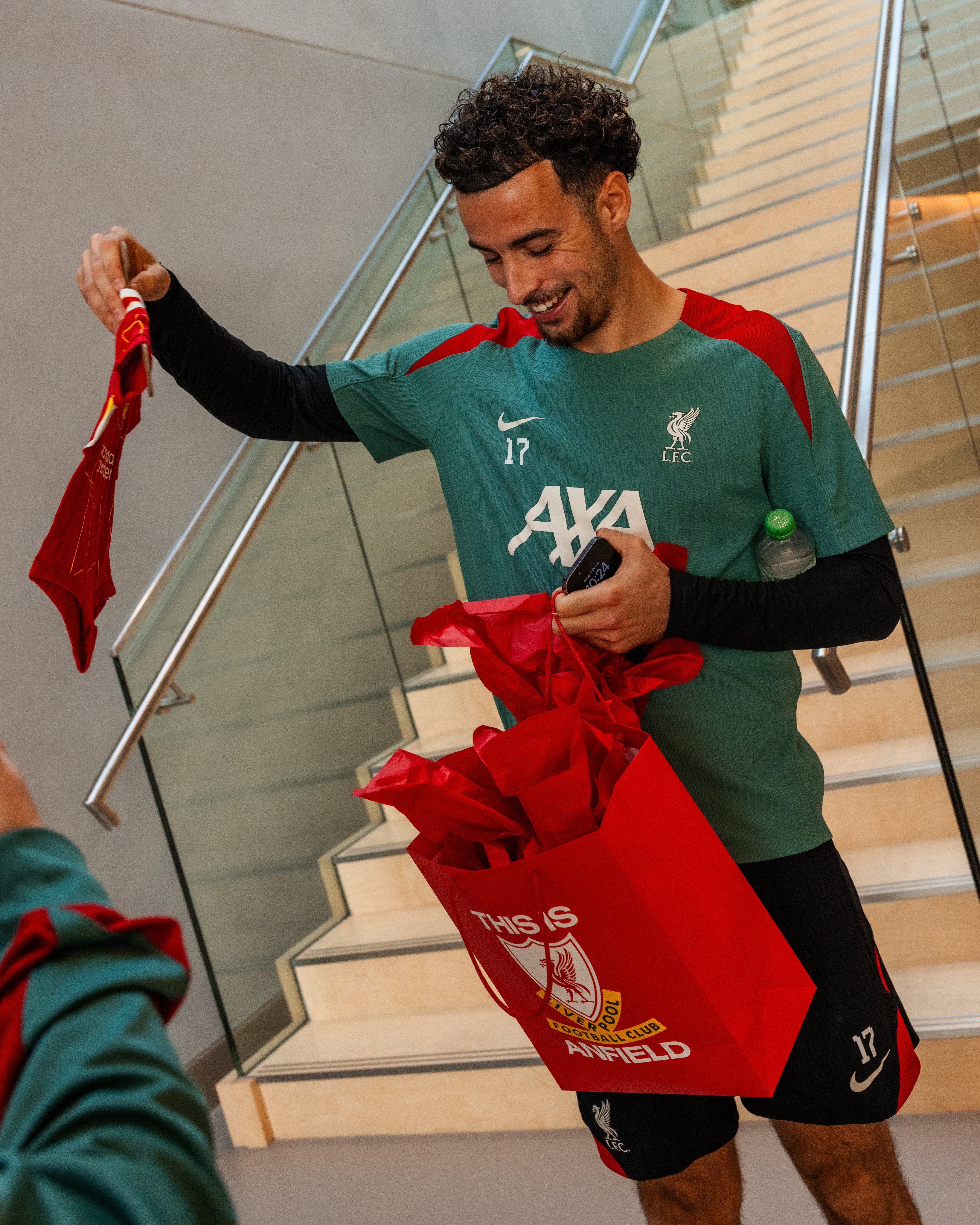 Photography of Curtis Jones opening a present at the AXA Training Centre.