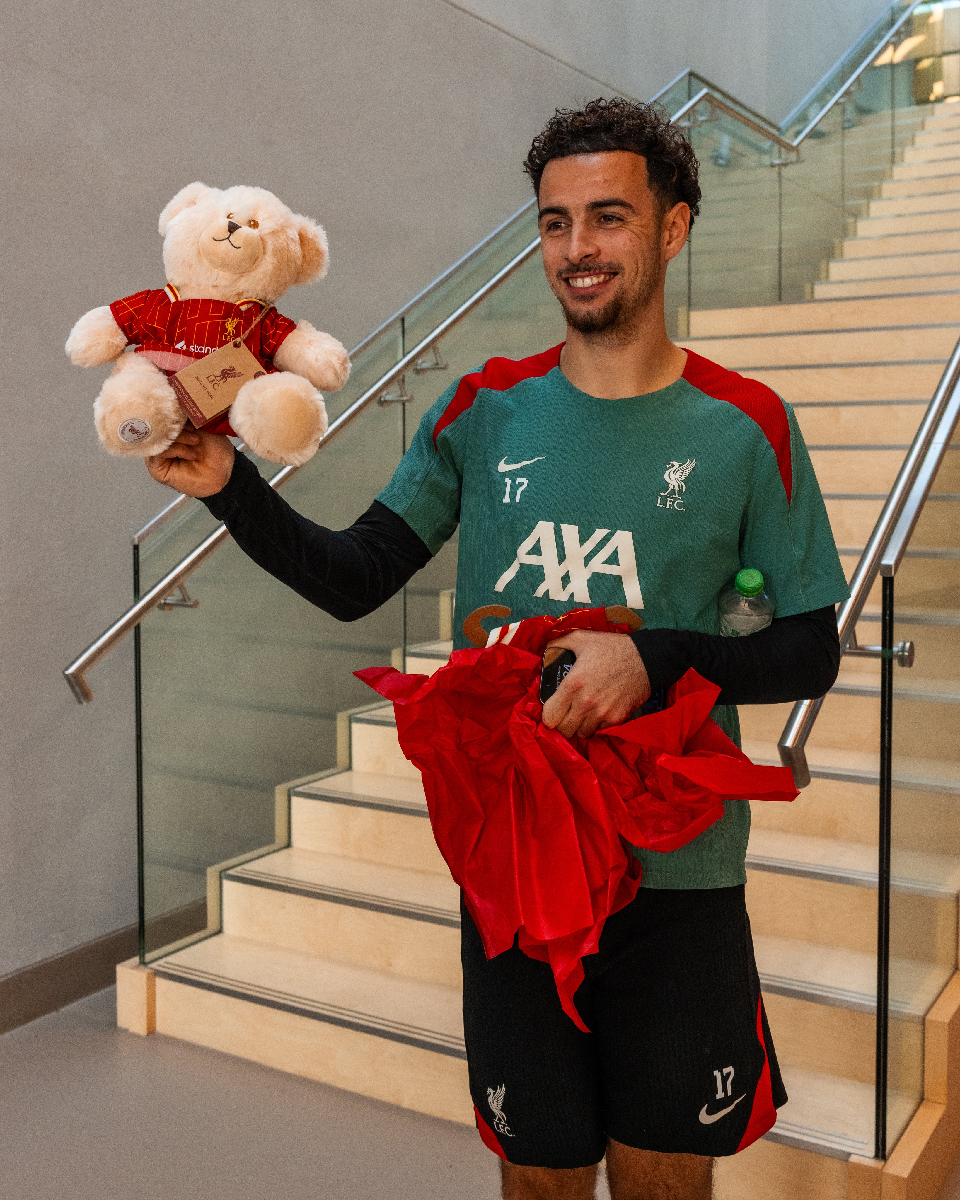 Photography of Curtis Jones opening a present at the AXA Training Centre.