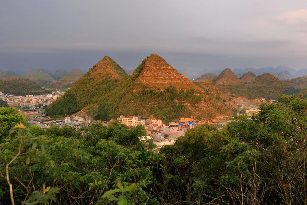 amazingguizhou2's tweet photo. ⛰Did the mysterious Egyptian pyramids move to #Guizhou? - #Anlong Pyramids
In the outskirts of #Anlong County, #Guizhou Province, several mountains, approximately 150 meters high, have attracted many visitors. With broad bases and sharp peaks, these mountains feature distinct angular shapes and layered rock formations that resemble "pyramids". Interestingly, these "Anlong Pyramids" are also located near the 30th parallel north, just like the "Egyptian pyramids", adding an air of mystery.
However, unlike the Egyptian pyramids, the Anlong pyramids are natural formations. These orderly conical "pyramids" belong to karst topography and were formed from dolomite rock over 200 million years ago. Periodic tectonic movements have caused the rocks to exhibit clear layering, and ongoing erosion of karst landforms has resulted in significant erosion in the upper rock layers, while the lower layers remain relatively intact. The simultaneous erosion in both horizontal and vertical directions creates the sharp peaks and broad bases that give these mountains their pyramid-like appearance.
This unique natural wonder showcases the incredible craftsmanship of nature and offers surprising beauty. Would you like to see the "pyramids" of Guizhou?💫
📷Image Source: Xinhua News
#AmazingGuizhou #AnlongPyramid #Guizhou #KarstTopography #NaturalWonders #MountainTourism #DolomiteRock #UniqueLandforms #ChineseGeography #NatureCraftsmanship #VisitorAttractions #TectonicMovements #Erosion #GuizhouTourism