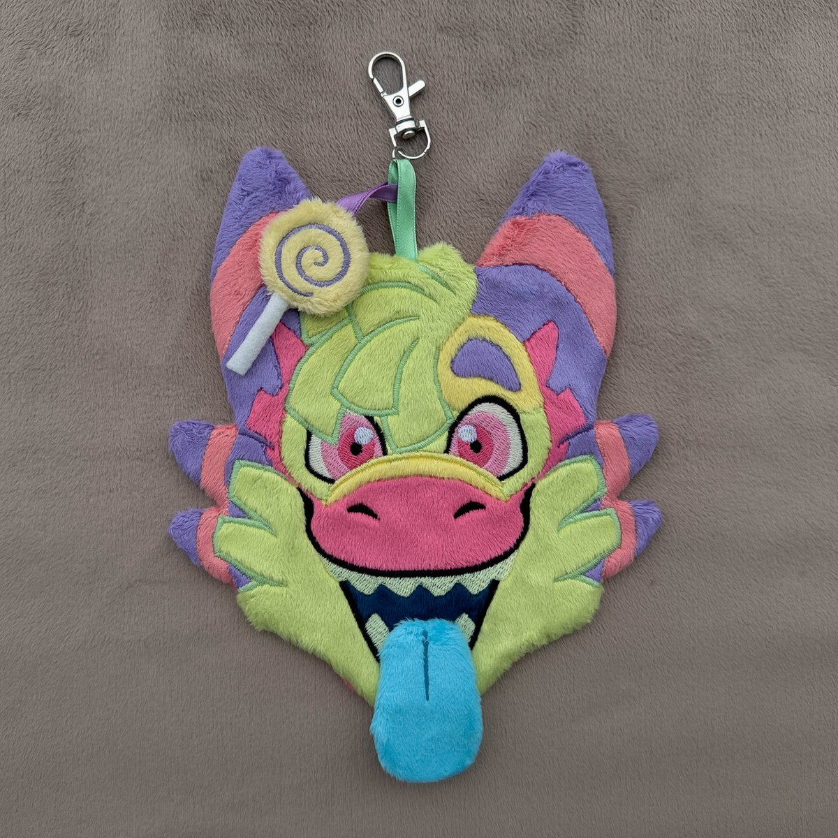 WispyChipmunk's tweet photo. One of two embroidered badge commissions for @CandyDergy, this one being his piñata sona Dañgo! I absolutely love this character's design and I was stoked to get to make him. He's 6"x7" has a removable magnetic tongue and an extra lollipop charm that attaches to the main loop! https://t.co/A2mEWqp09D
