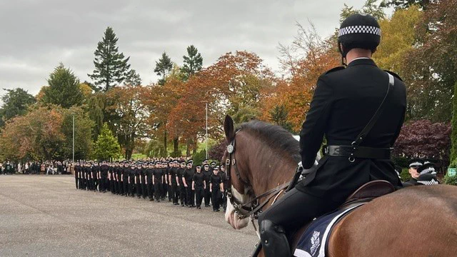 A mounted police officer wears a formal uniform, as they sit astride a chestnut coloured horses with a white muzzle on Parade Square at Police Scotland Headquarters, Tulliallan, which homes the Scottish Police College.

The officer and police horse overlook new police officers are they march away from Parade Square in a formal line, as they've just completed their passing out ceremony. 