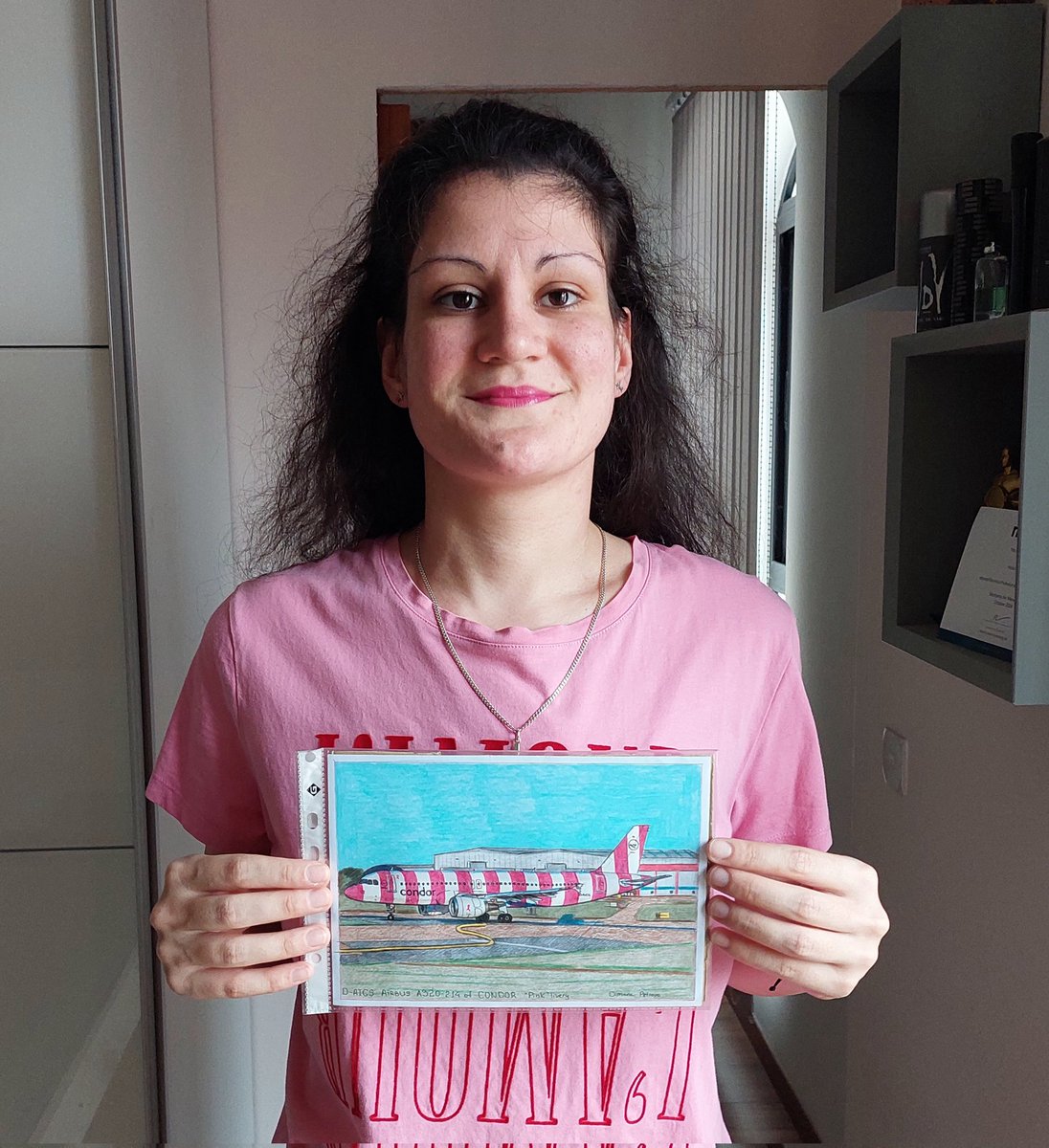 AircraftBy's tweet photo. Pink October 2024:
Me posing with my artwork of @Airbus A320-214. of @Condor painted with the special "Breast Cancer Awarness" pink livery. 🩷 ✈️✍️
The pink colour symbolizes the fight against breast cancer.
#PinkOctober2024 #CondorAirlines #BreastCancerAwarenessMonth #drawing https://t.co/givC37YGmC