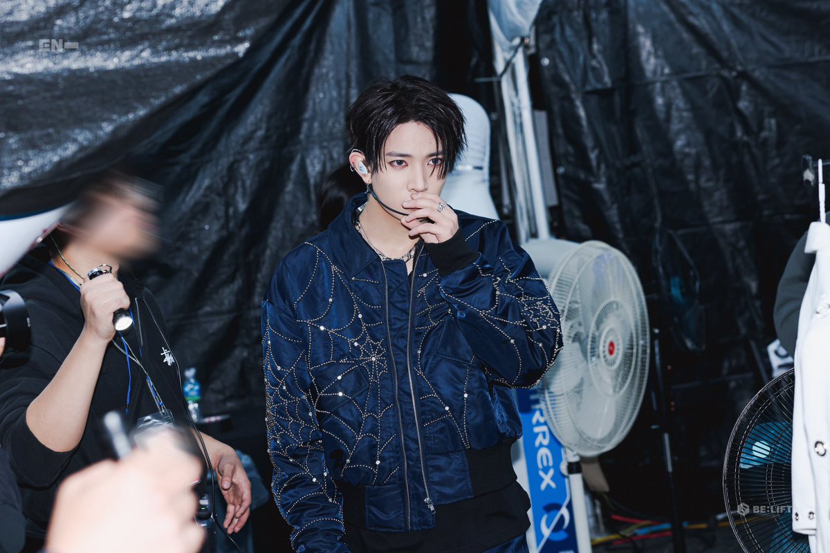 Moments before the spotlight hits, draped in a web of style and anticipation.