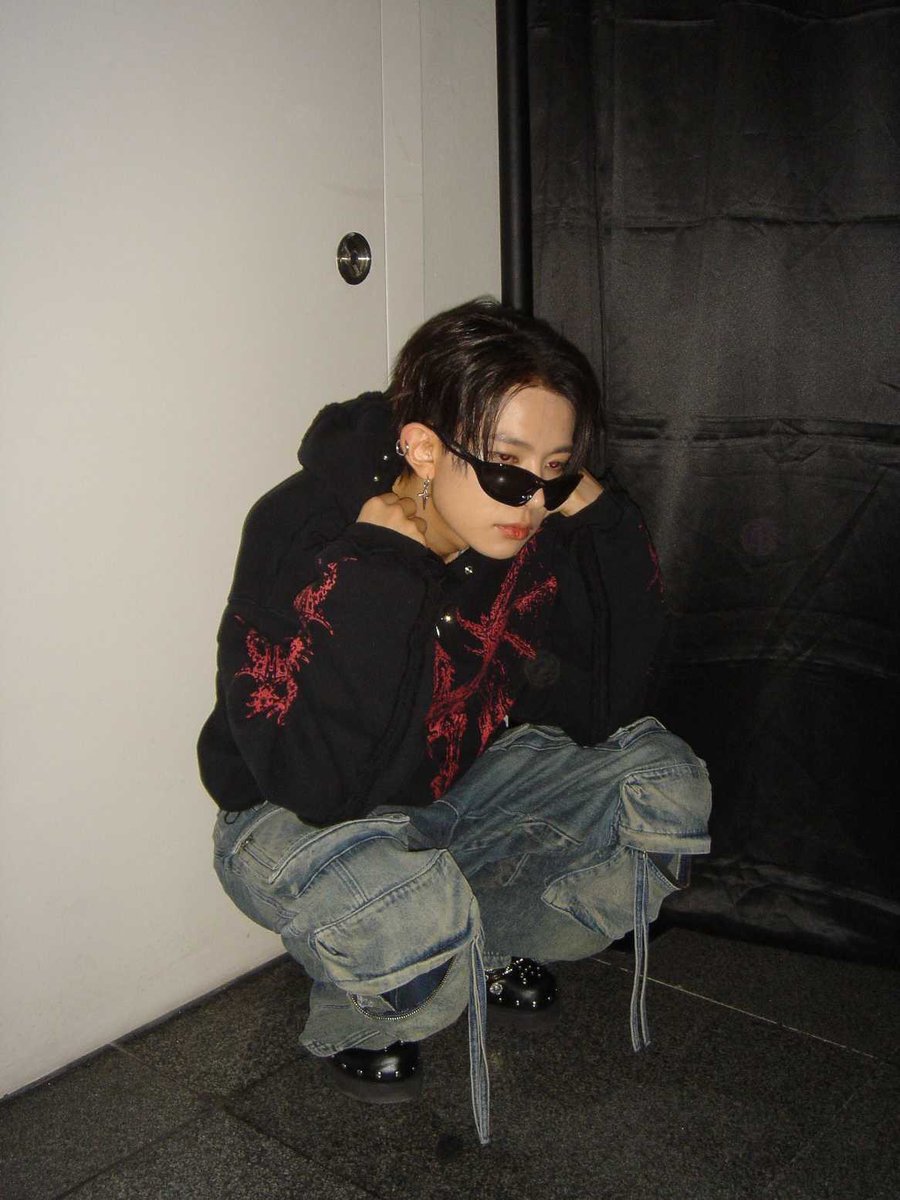 Effortlessly cool in oversized cargo pants and dark shades, bringing a grunge vibe with edgy streetwear style.