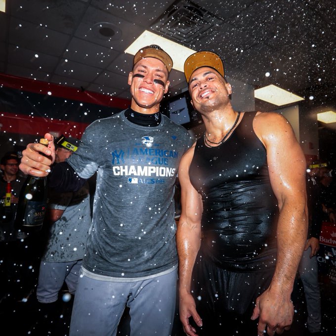 Aaron Judge and Giancarlo Stanton pose for a photo in the midst of champagne showers.