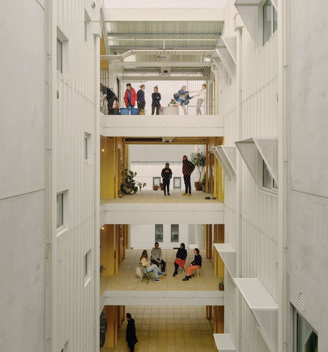 fæ að deila þessu fjölbýlishúsi hér - svalagangar, reiðhjólageymslur, stigagamgar og handriði til að engjast yfir …