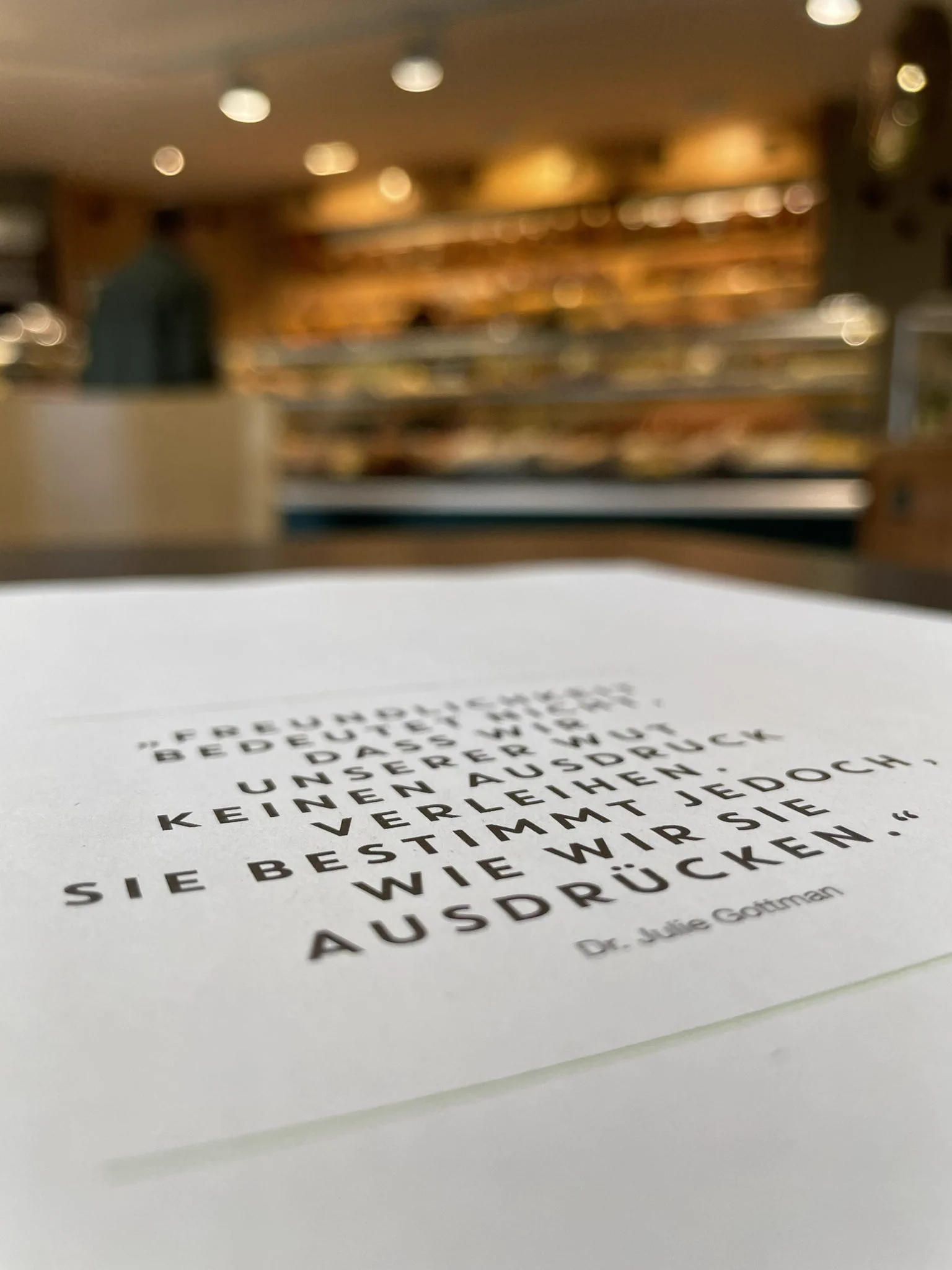 A text in a magazine photographed in focus. Text says: „Freundlichkeit bedeutet nicht, dass wir unserer Wut keinen Ausdruck verleihen. Sie bestimmt jedoch, wie wir sie ausdrücken“ by Dr. Juli Gottman