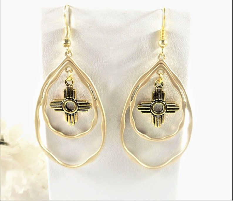Adorn yourself with the elegance of Gold Zia Teardrop Earrings. Perfect for all New Mexico lovers!  Add the gold Zia pendant to add a touch of southwestern charm to your style. buff.ly/4eMXur2 #NewMexicoJewelry #ZiaEarrings #ZiaPendant #wiseshopper #GoldZiaJewelry