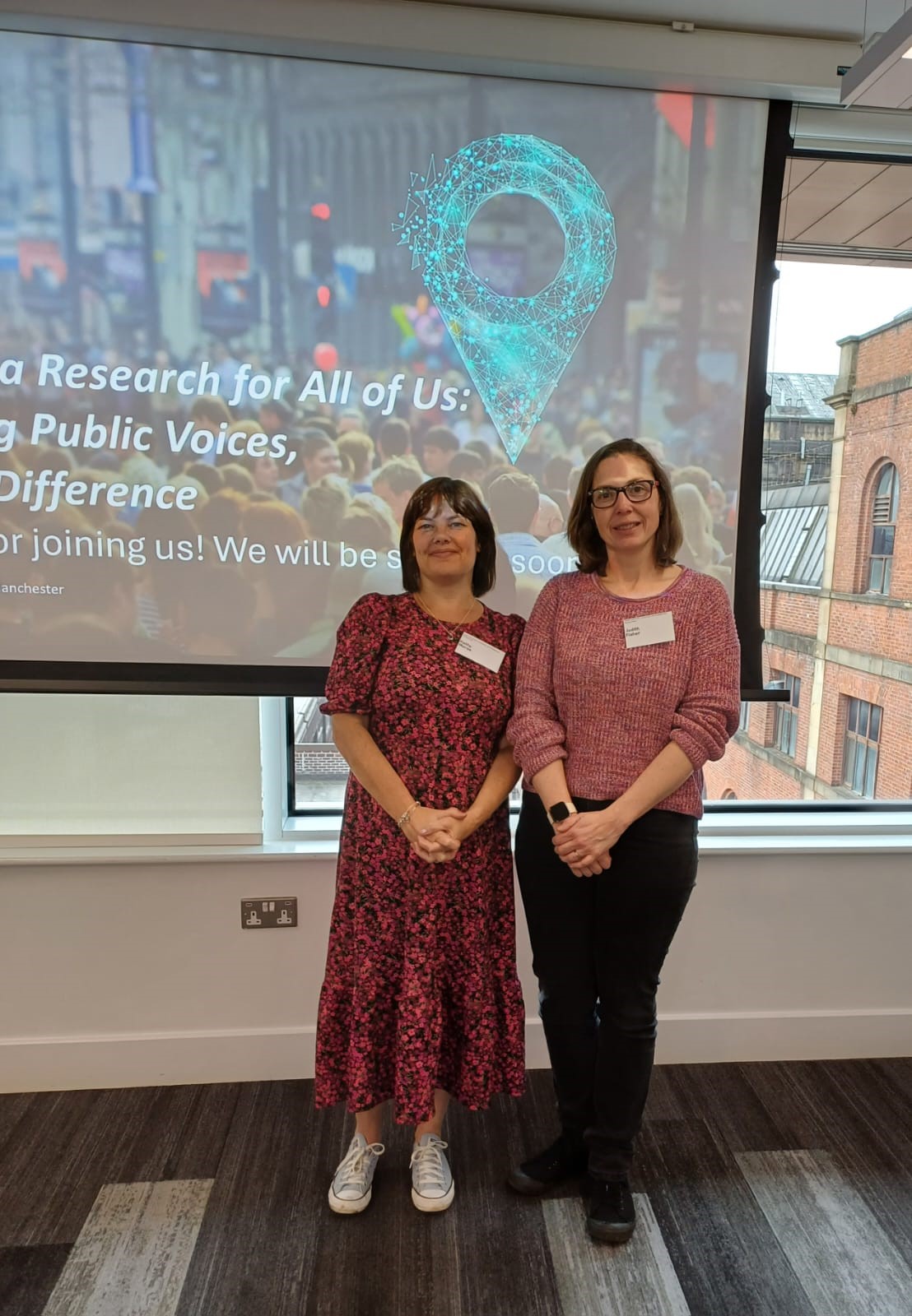Judith and Kathy standing in front of an HDR UK projector screen