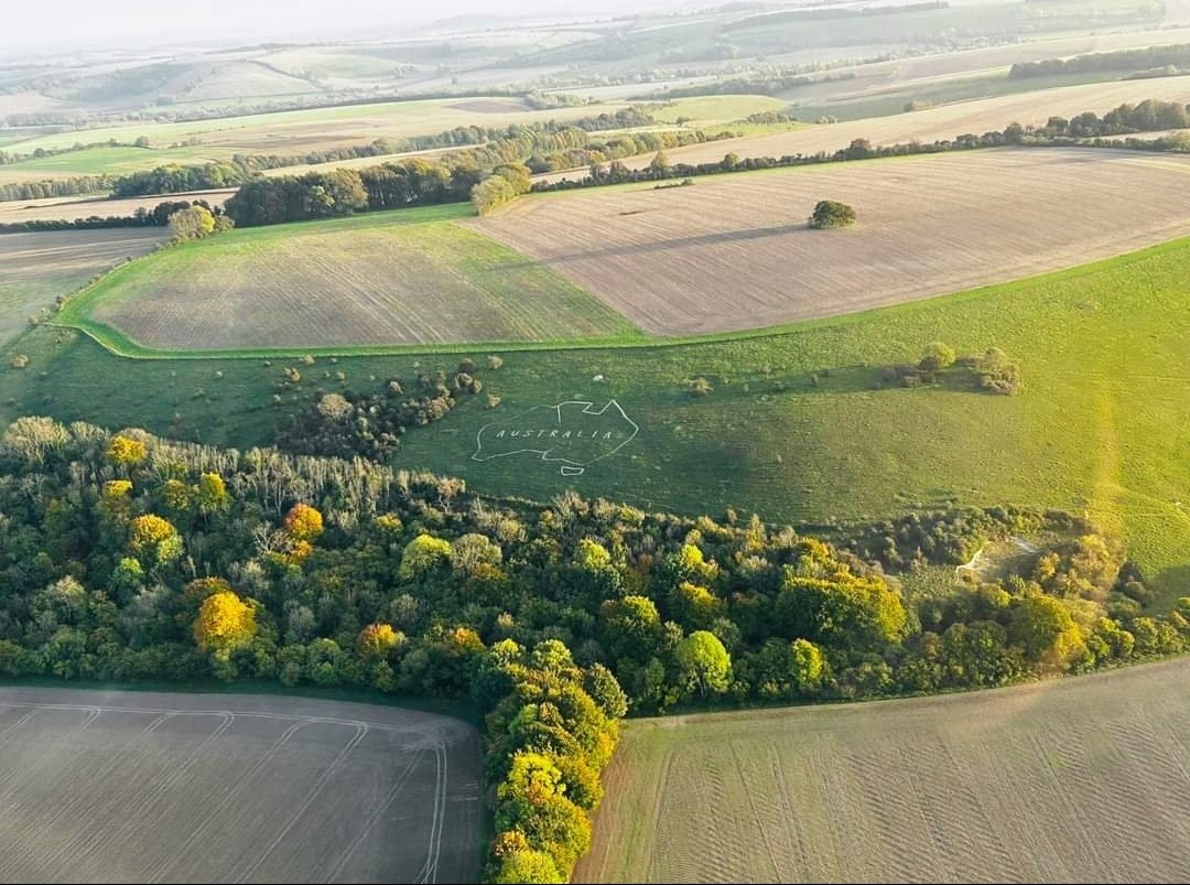 ww1australiamap's tweet image. We have just been sent this fab photo, taken by Andy Hardy, an Australian, flying past Australia in #Wiltshire! The Autumnal colours are starting to come through and our recent work on the north coast is showing up well. The badge was created in 1917 by Australian soldiers #WW1